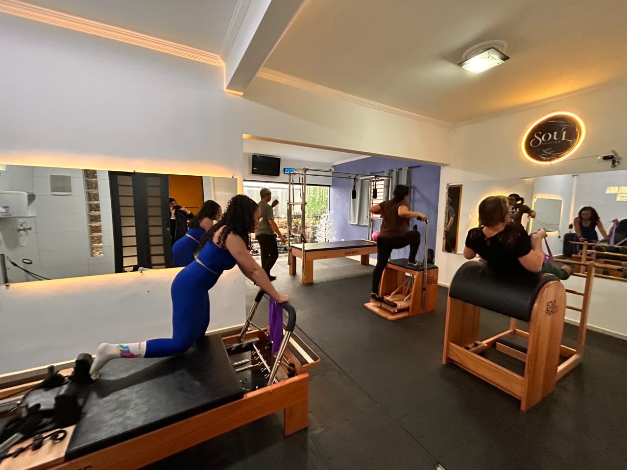 Sala principal de Pilates com aparelhos de madeira: Cadillac, Reformer, Chair e Barrel